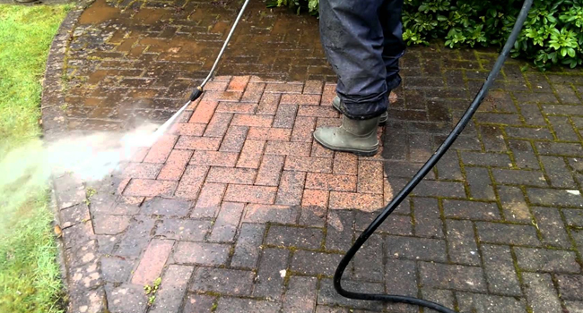 Driveway being cleaned with a pressure washer
